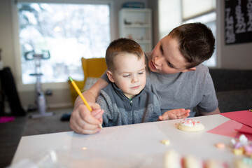 sister helping brother's write valentine's day notes