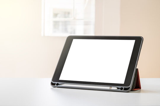 Technology: Mockup tablet mobile stand on the table with blur background in the free workspace area.