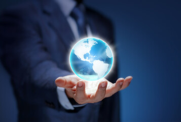 Global business world in hand. Businessman wear suit holding the planet earth on blue background. Man show USA world map for communicate, connection, technology, worldwide, network, internet concept.