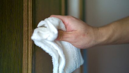ドアノブを拭く男性の手