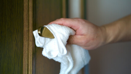 ドアノブを拭く男性の手
