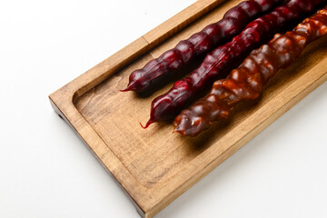 Churchkhela served on a wooden board over white background. Traditional Georgian dessert, Georgian cuisine concept.