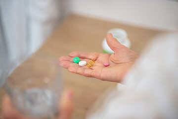 Close up picture of womans hand with pills on it