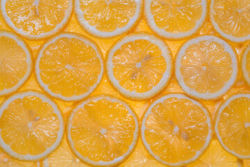 Slices of fresh lemon under water textured background.