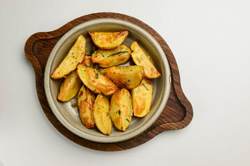 Baked potato with rosemary served in a ceramic bowl over white background. Delicious idea for dinner.