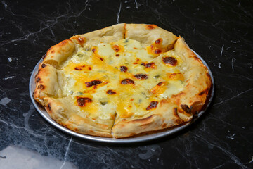 A Pepperoni pizza on black marble table background. Traditional Italian cuisine concept.