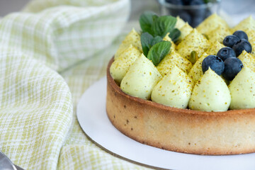 Round blueberry pie with green pistachio cream and strawberry jam
