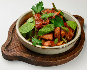 Gourmet cut steak with green asparagus. Served in a white bowl over white background. Georgian cuisine concept.