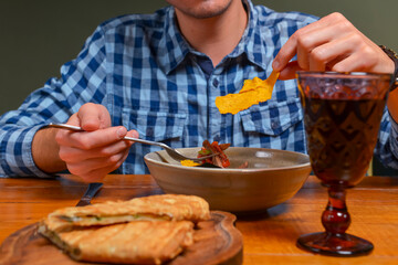 Young man eating salad in restaurant or diner. Georgian cuisine restaurant concept. Vegetable salad with lavash roll.