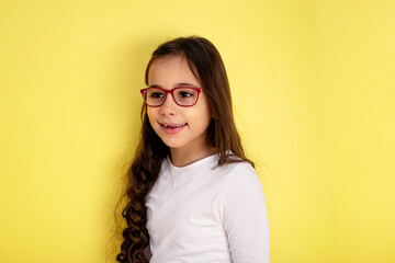 Obraz premium Funny child girl in glasses on colored background
