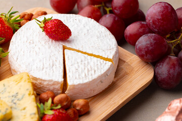 Composition of cheese, and fruits on gray table