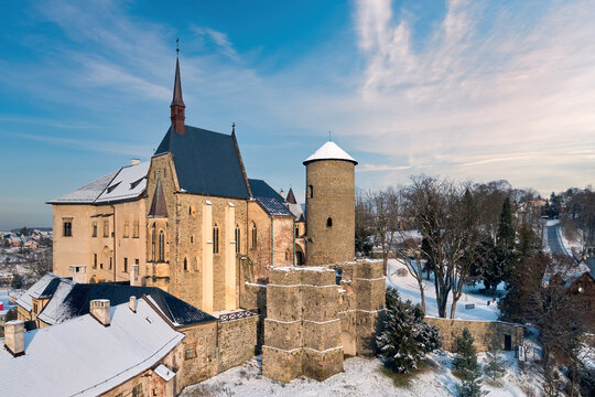 Aerial, winter view of an authentic renaissance castle Sternberk and its gothic fortification covered by snow against blue sky. Czech landscape, Central Moravia, Czech republic.