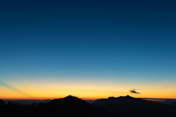 Heaven at early morning with copy space. Sunset, sunrise backdrop.Predawn clear sky with orange horizon and blue atmosphere. Smooth orange blue gradient of dawn sky.
