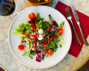 Salad with pearl mozzarella and fresh vegetables closeup