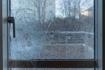 Broken balcony glass door window with shattered glass