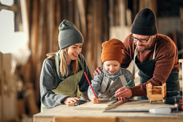 Happy family working together in carpentry workshop