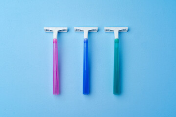 Set of disposable razors for women on blue background