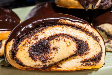 Rolled buns with poppy seeds, covered with chocolate icing