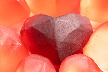 Sweet red gummies in the shape of a heart, on a light background