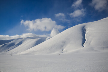 Fototapeta na wymiar Winter wonderland: view of Pian Grande covered by snow on winter day of sun in Umbria