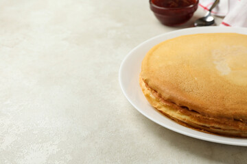 Concept of breakfast with plate of thin pancakes and jam on white textured background