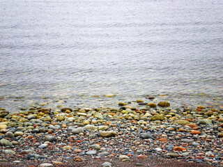 Little green rolling stones at the coastline 