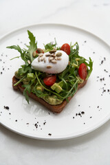 Poached egg toast with guacamole avocado sauce.