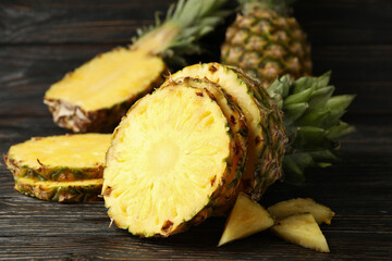 Ripe cutted pineapple on wooden background, close up