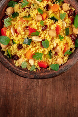 Couscous close-up in a tagine, top shot with copy space on a dark background