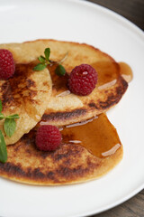 Healthy oat pancakes with raspberry berries and honey syrup