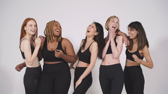 Mixed race group of models posing, laughing. women with different body size and appearance enjoy spending time together.