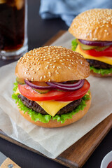 Burgers with cutlet, tomato, lettuce, cucumber, onion and cheese. American cuisine. Fast food. Cheeseburger.