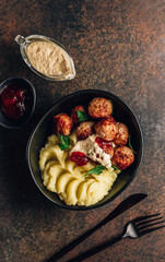 Swedish meatballs with mashed potatoes, gravy and lingonberry jam on dark background. Top view