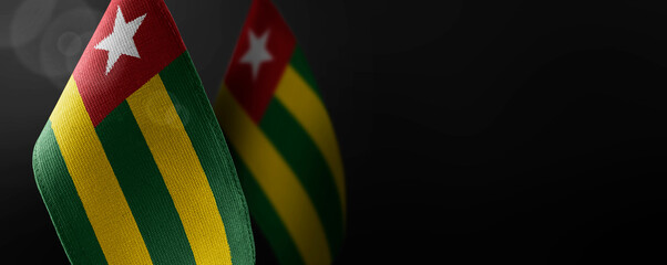 Small national flags of the Togo on a dark background