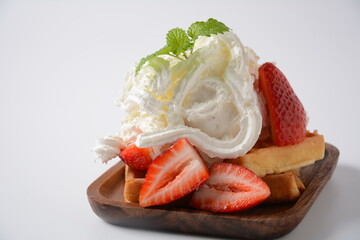 Belgian waffles with strawberries, whipped cream and mint leaves. Tasty dessert concept