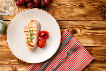 Fototapeta na wymiar Grilled chicken breast served with cherry tomatoes on table