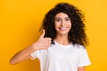 Photo portrait of happy smiling curly girl showing like sign advising promoting isolated on vivid...