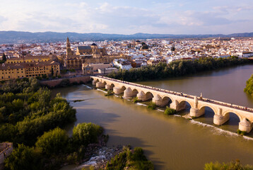Fototapeta na wymiar Roman Bridge over the Guadalquivir from aerial panoramic view with Mosque-Cathedral in Cordoba