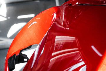 Closeup shot of the disassembled vehicle. Professional paint job. New shiny red color, car repair...