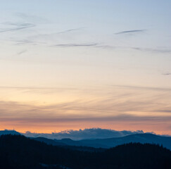 Obraz premium Panorama of the silhouette of mountains and forest on the background of sunset