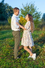Fototapeta premium Stunning sensual outdoor portrait of a young stylish fashion couple kissing in the summer