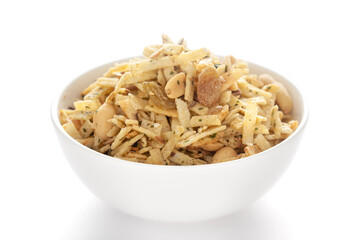 Aloo Mixture in a white ceramic bowl made with potatoes, peanuts, raisins, etc. Pile of Indian spicy snacks (Namkeen), under backlight, side view, against the white background.