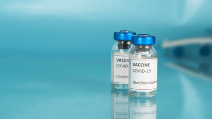 Coronavirus sars-cov-2 vaccine vial. The wing of the plane in blue background. Covid-19 vaccination with vaccine bottles. Vaccine against the pandemic. Copy space.