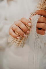 burly large female fingers festive manicure with stones and sequins holding bride's bouquet of dried flowers, vertical content, unrecognizable person, selective focus