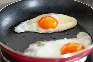 Two fried eggs in a frying pan, closeup