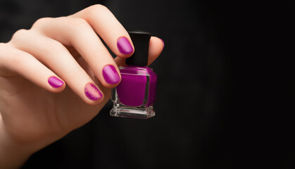 Female hand with pink nail design. Pink nail polish manicure. Woman hand hold pink nail polish...