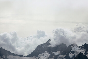 Fototapeta na wymiar Snow capped mountain range in the clouds. Caucasus, Russia