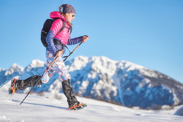 Young sporty woman in the snow with crampons and gaiters