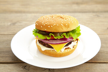 Burger in a white plate on grey wooden table
