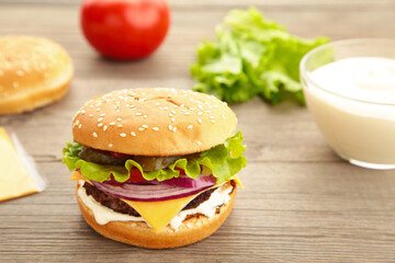 Homemade burger ingredients arranged on wooden background